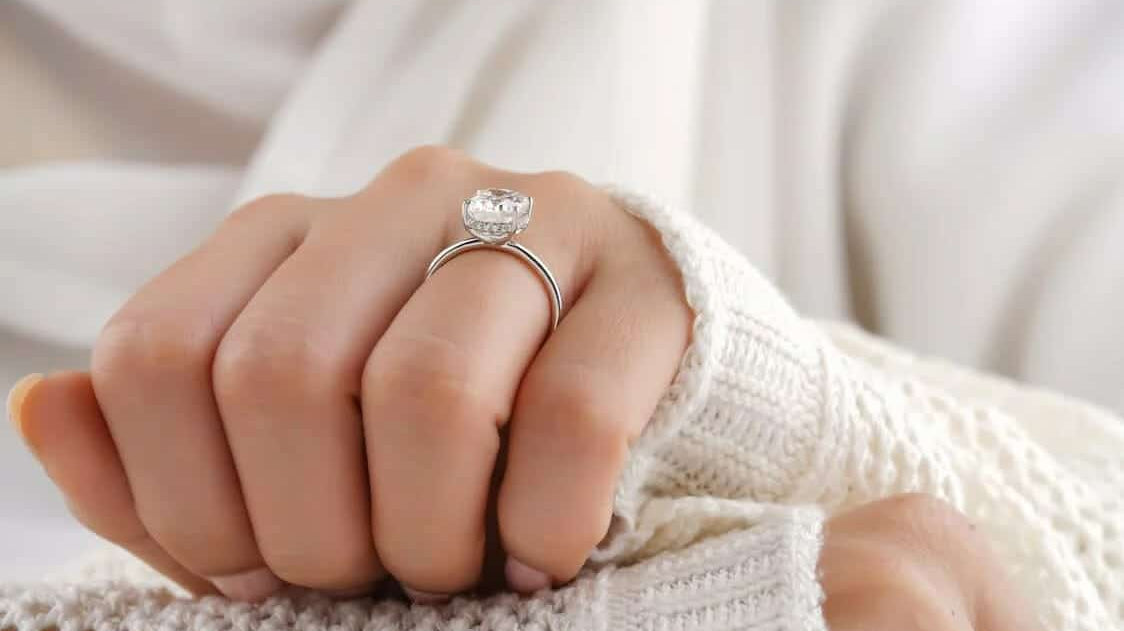 A person posing their hands to show off their engagement ring from upcoming 2023 jewellery trends