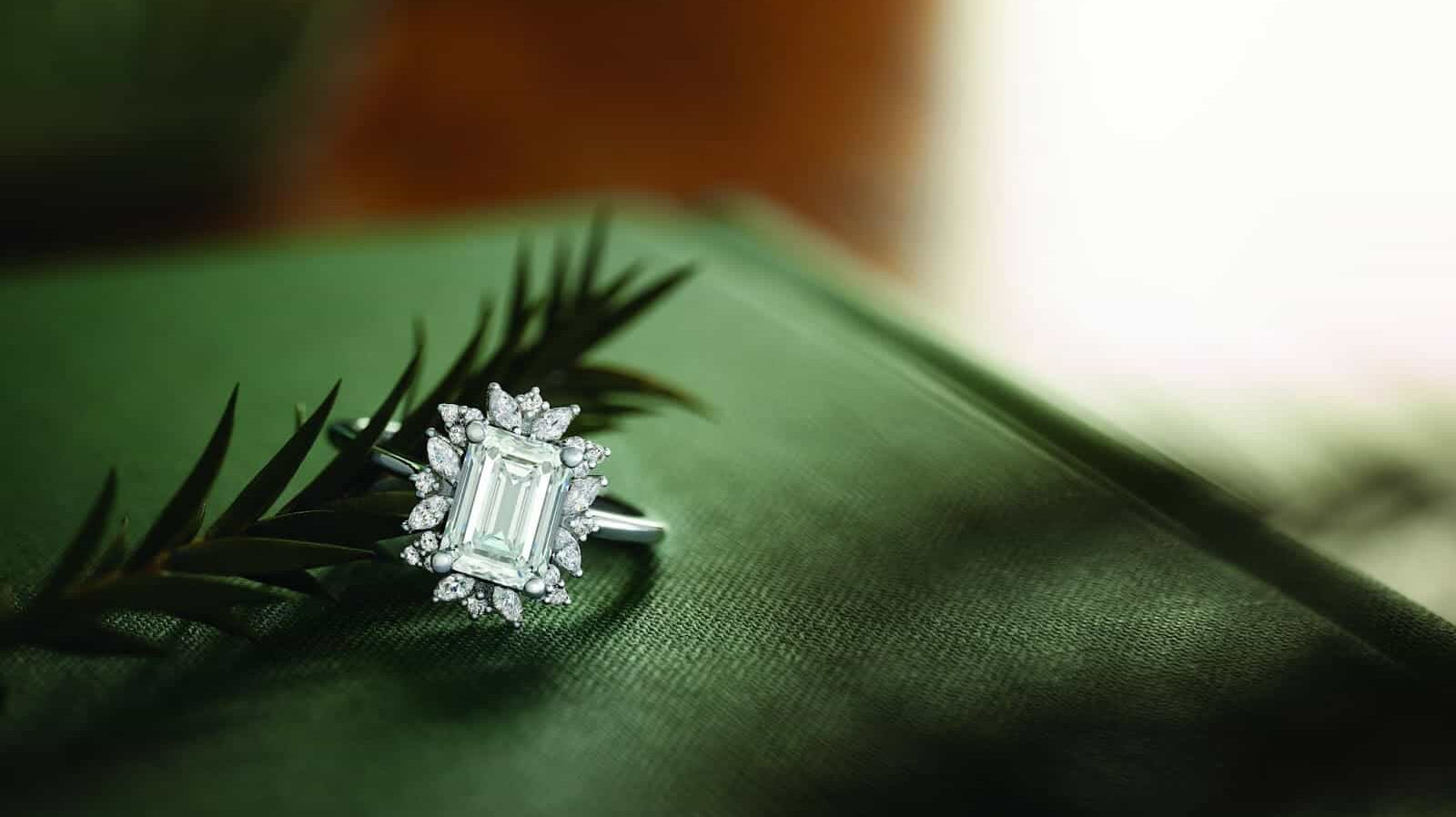 A stunning ADX holiday jewellery gift diamond ring on a green holiday themed surface.