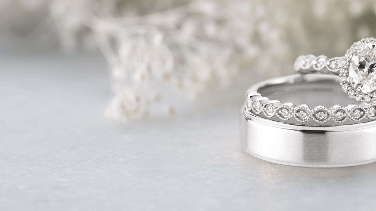 Ethically sourced engagement ring and wedding band sitting on the right of a decorated scene and table.