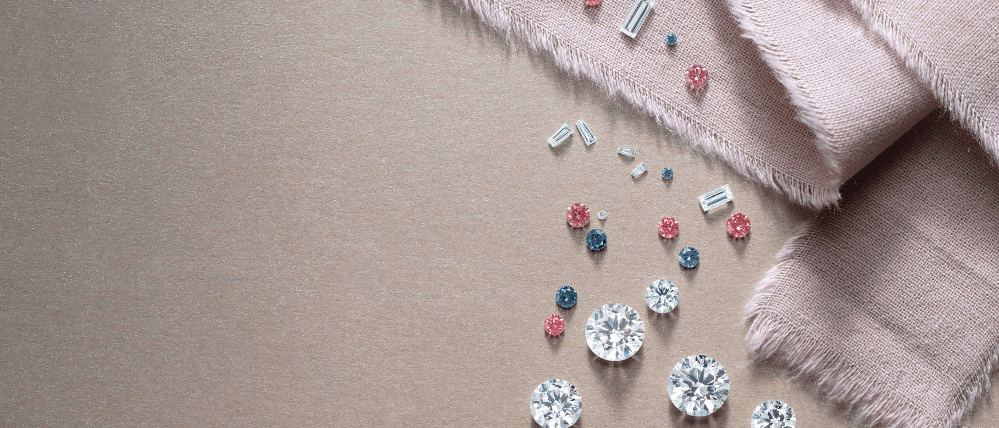 Natural and Lab-grown diamonds in various sizes, cuts and colors on a beige surface