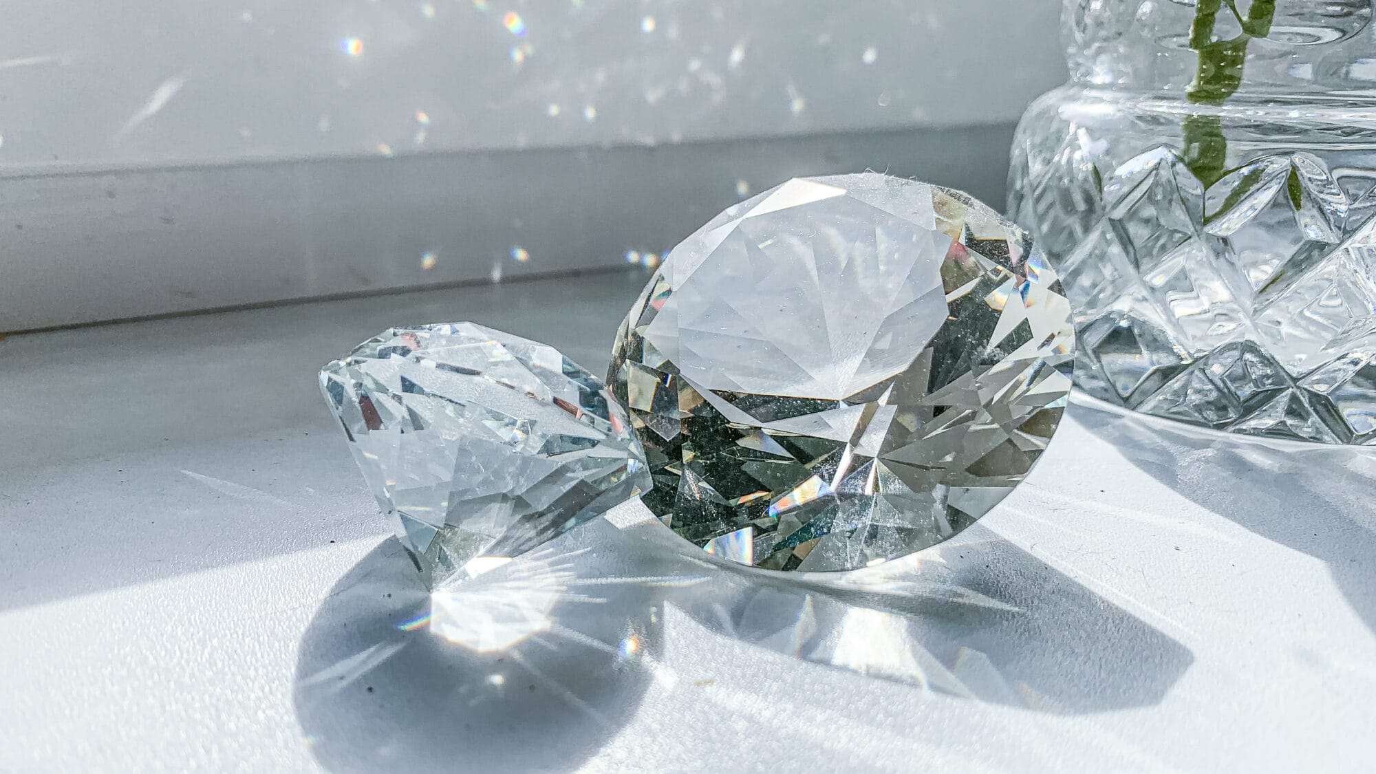 2 large diamonds on a. white table sparkling in the sunlight