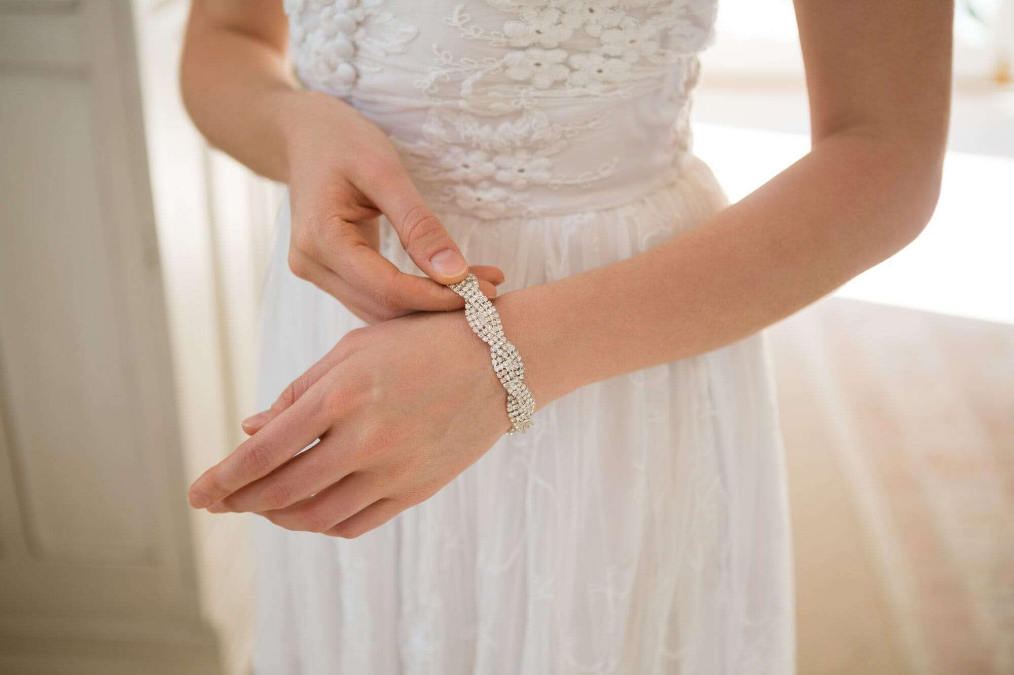 Midsection of bride wearing bracelet while standing at home