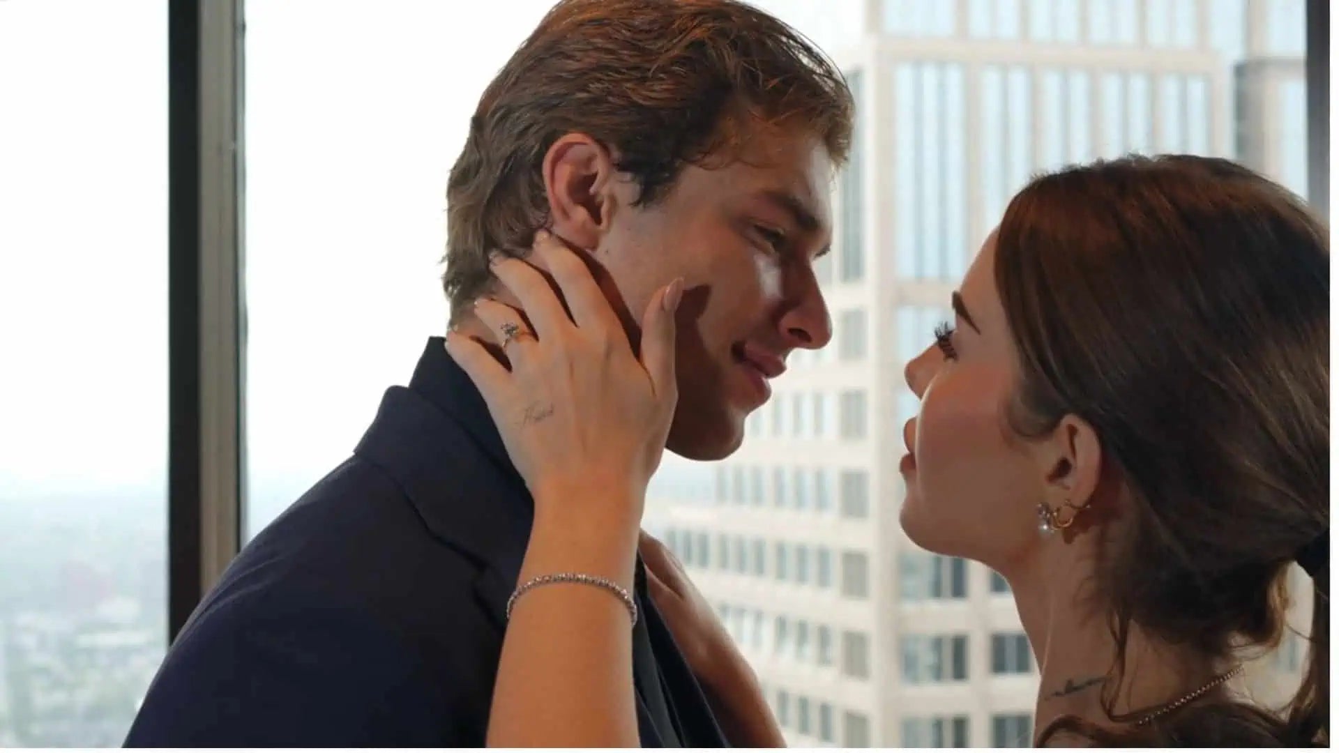 Romantic close-up of a couple sharing an intimate moment by a window, with the woman wearing a diamond ring and bracelet, softly highlighting the jewelry.